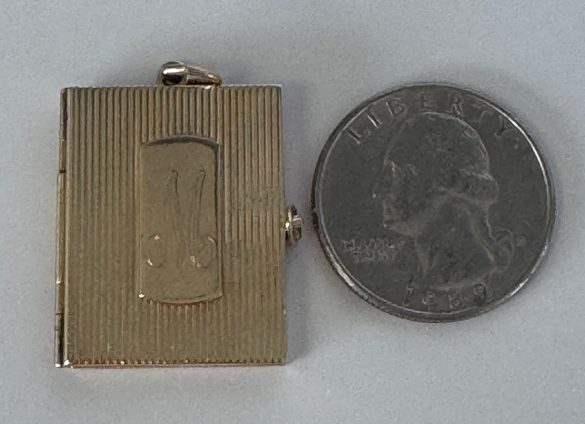 Vintage 14K gold book locket with hinged pages, engine-turned texture, engraved details, multiple photo compartments
