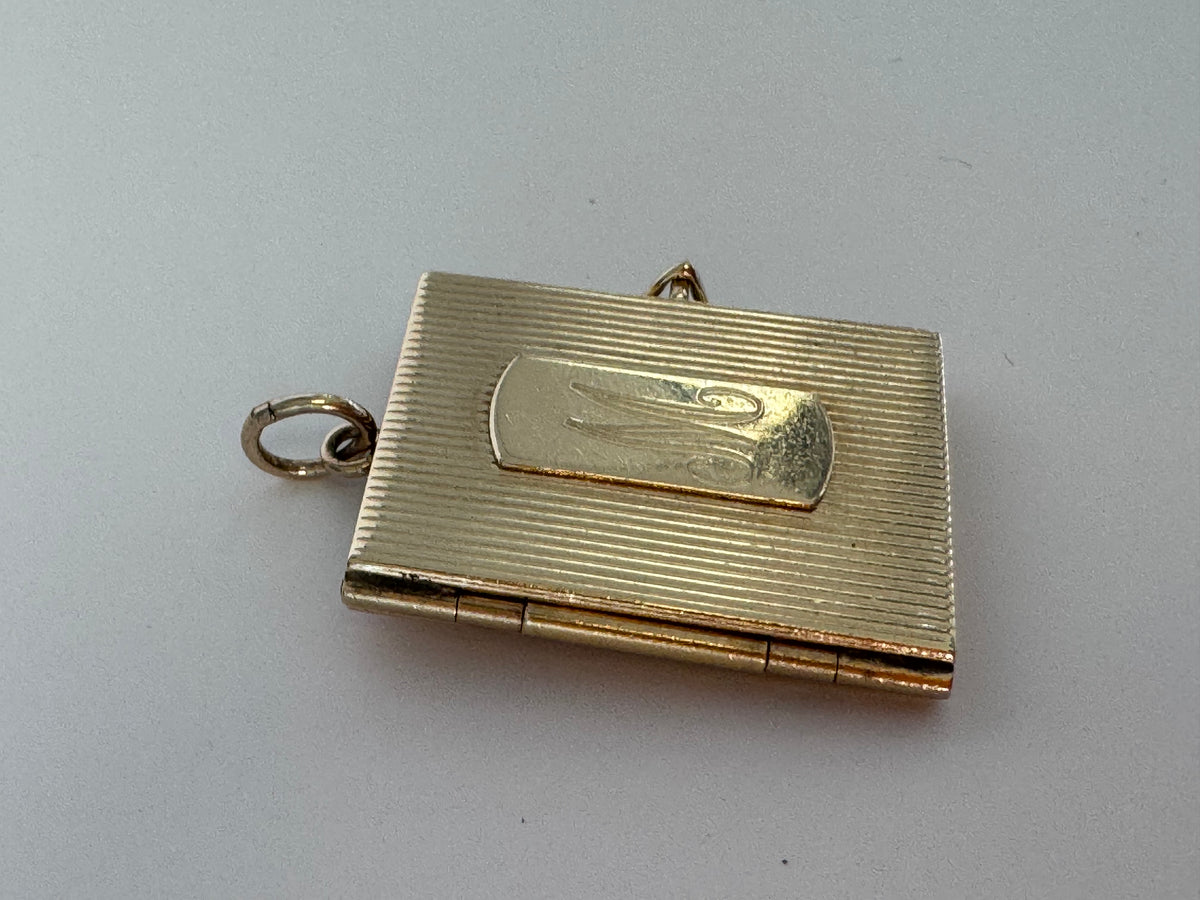Vintage 14K gold book locket with hinged pages, engine-turned texture, engraved details, multiple photo compartments
