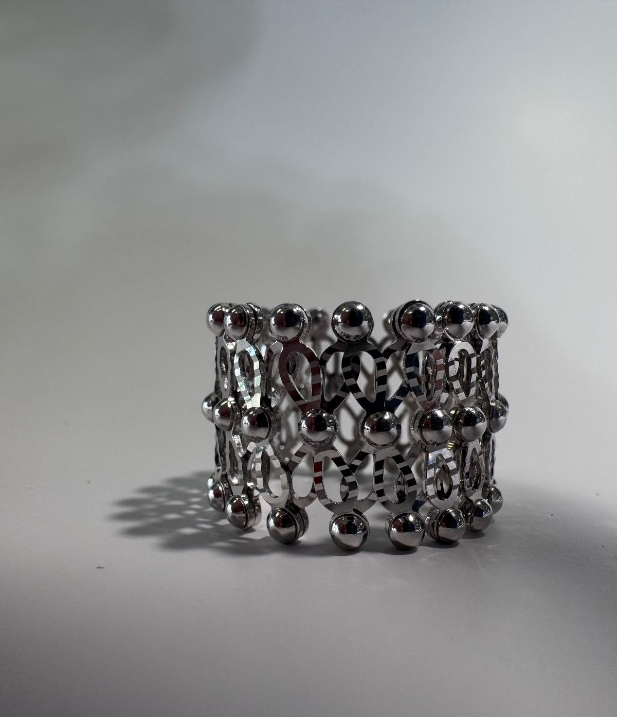 Silver beaded ring on a light gray background