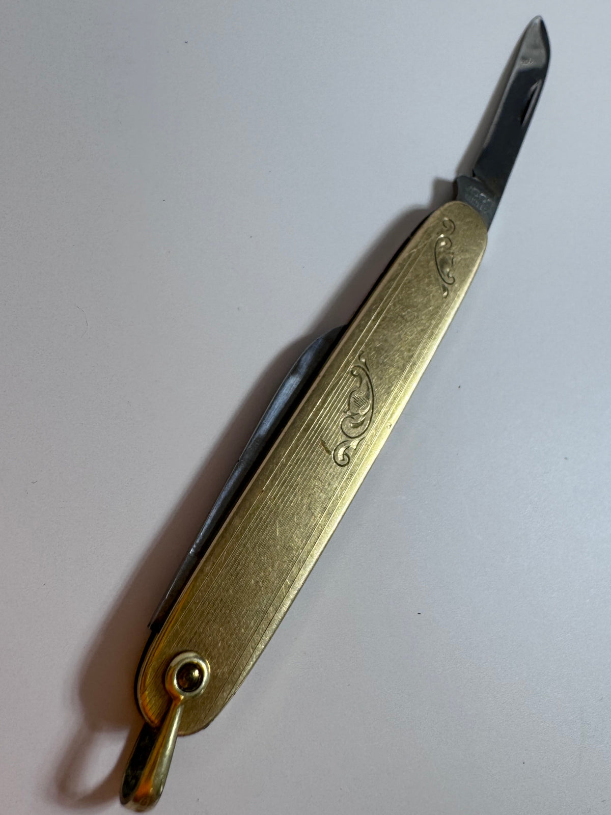 Vintage 10K gold pocket knife pendant with working steel blade, engine turned texture and engraved details, functional jewelry
