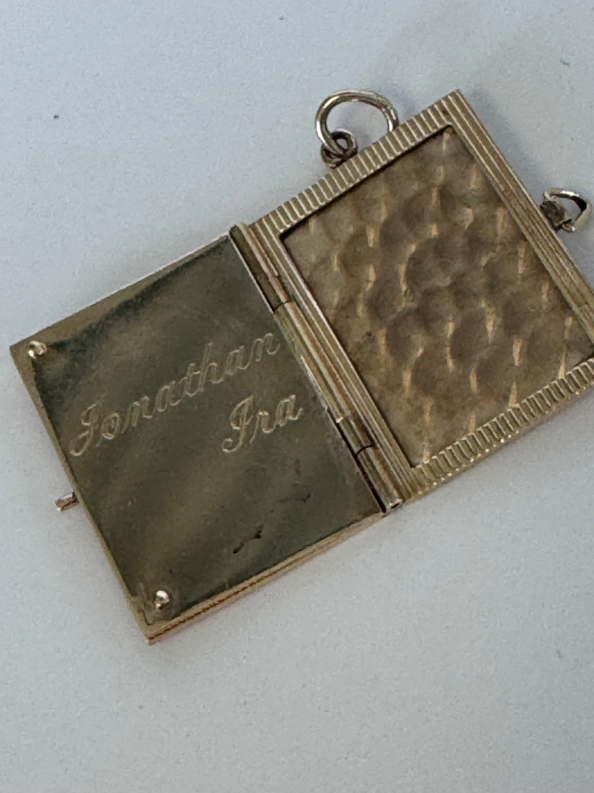 Vintage 14K gold book locket with hinged pages, engine-turned texture, engraved details, multiple photo compartments