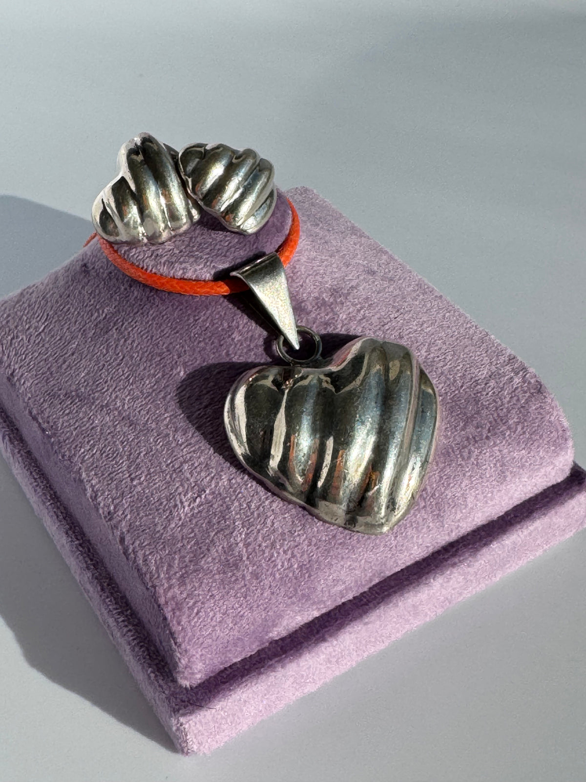 Sterling silver puffy heart jewelry set including cuff bracelet, stud earrings, and pendant with orange cord