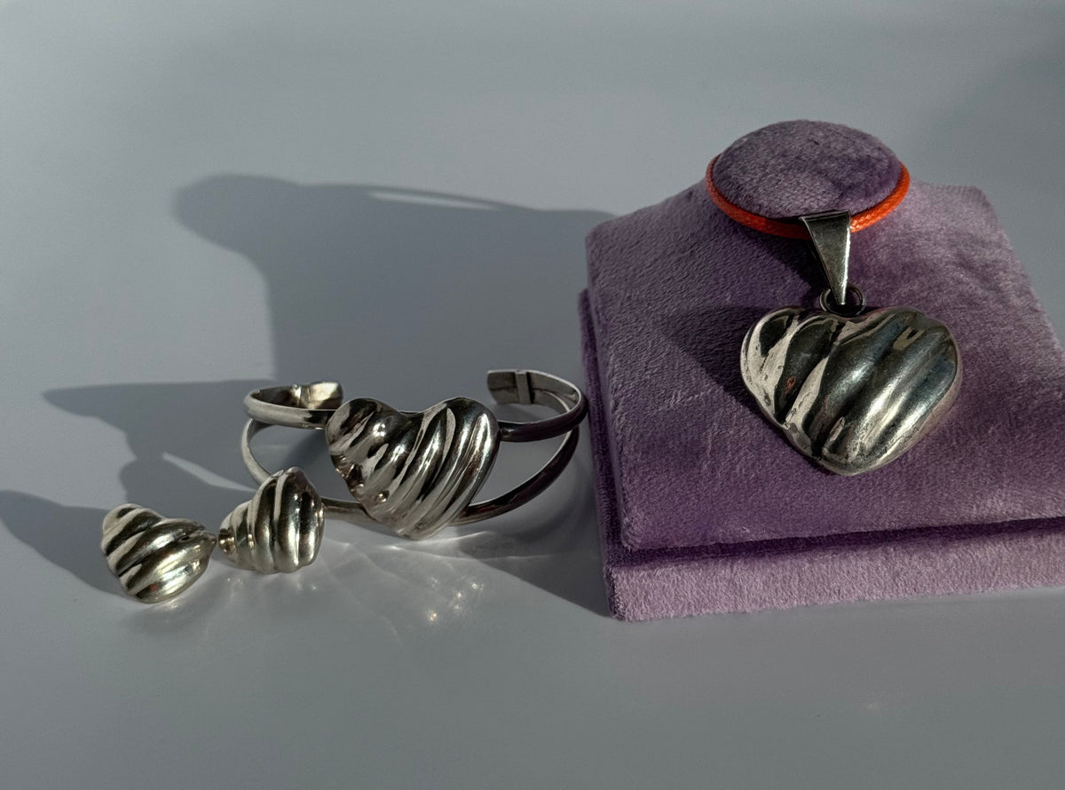 Sterling silver puffy heart jewelry set including cuff bracelet, stud earrings, and pendant with orange cord