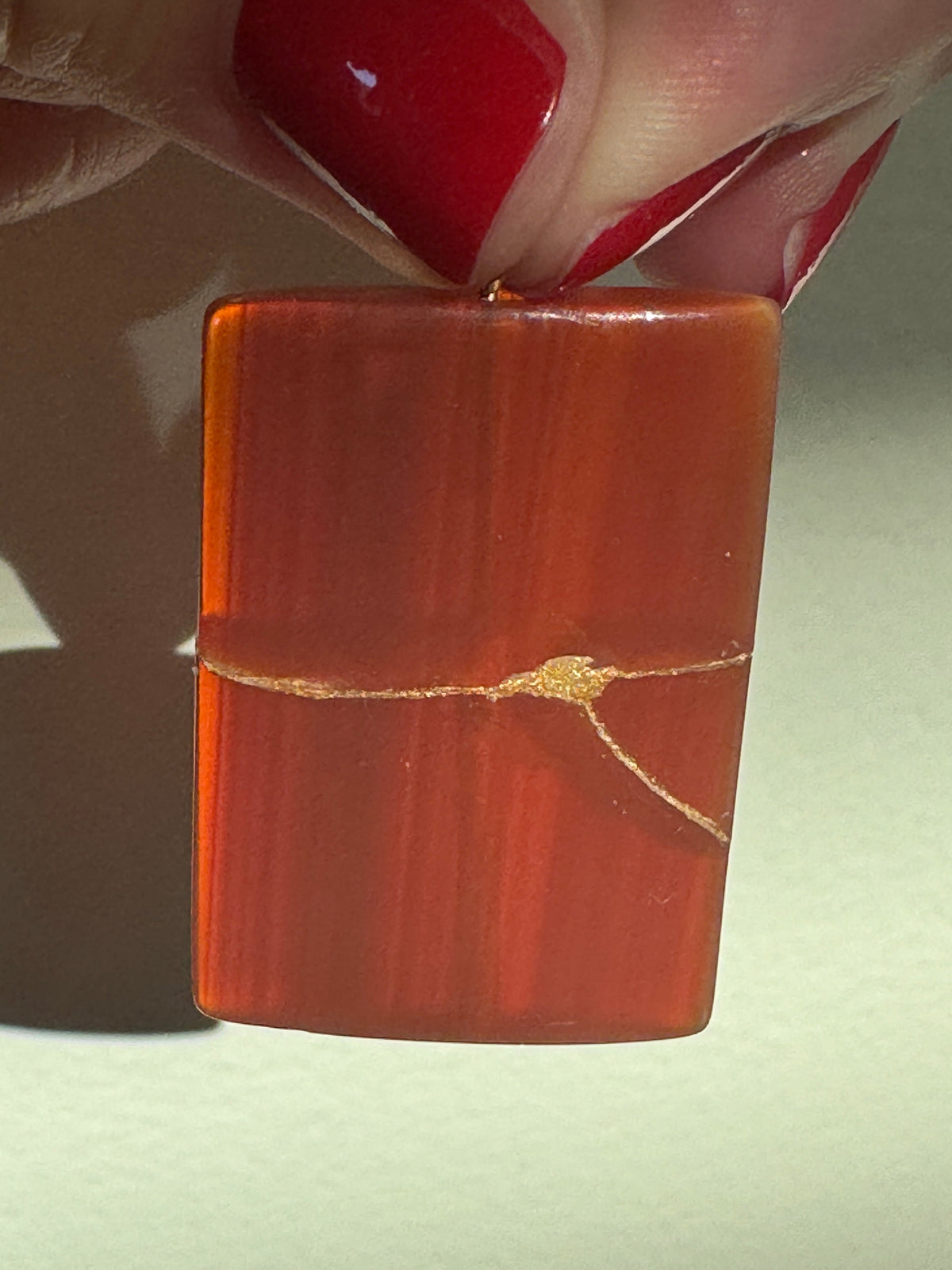 Estate 14K gold pendant featuring natural red carnelian rectangle with dramatic gold strike mineral inclusions embodying wabi sabi aesthetics