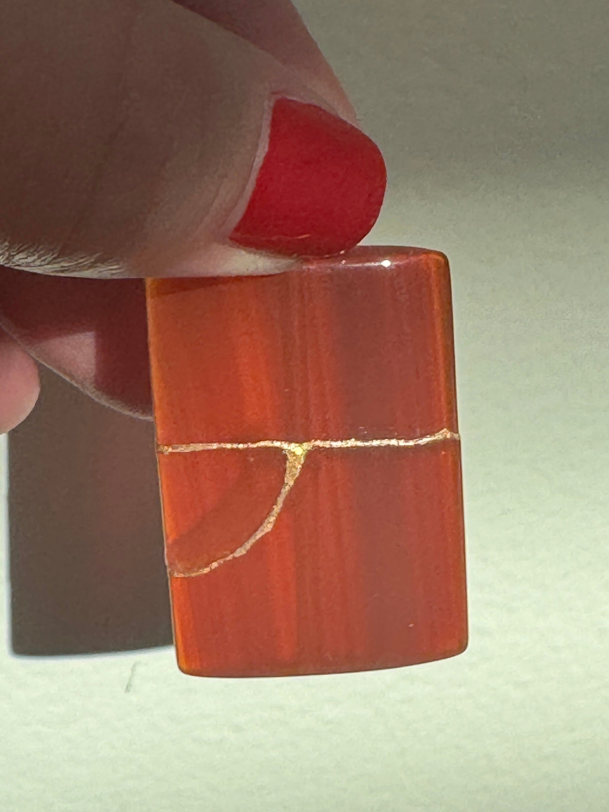 Estate 14K gold pendant featuring natural red carnelian rectangle with dramatic gold strike mineral inclusions embodying wabi sabi aesthetics