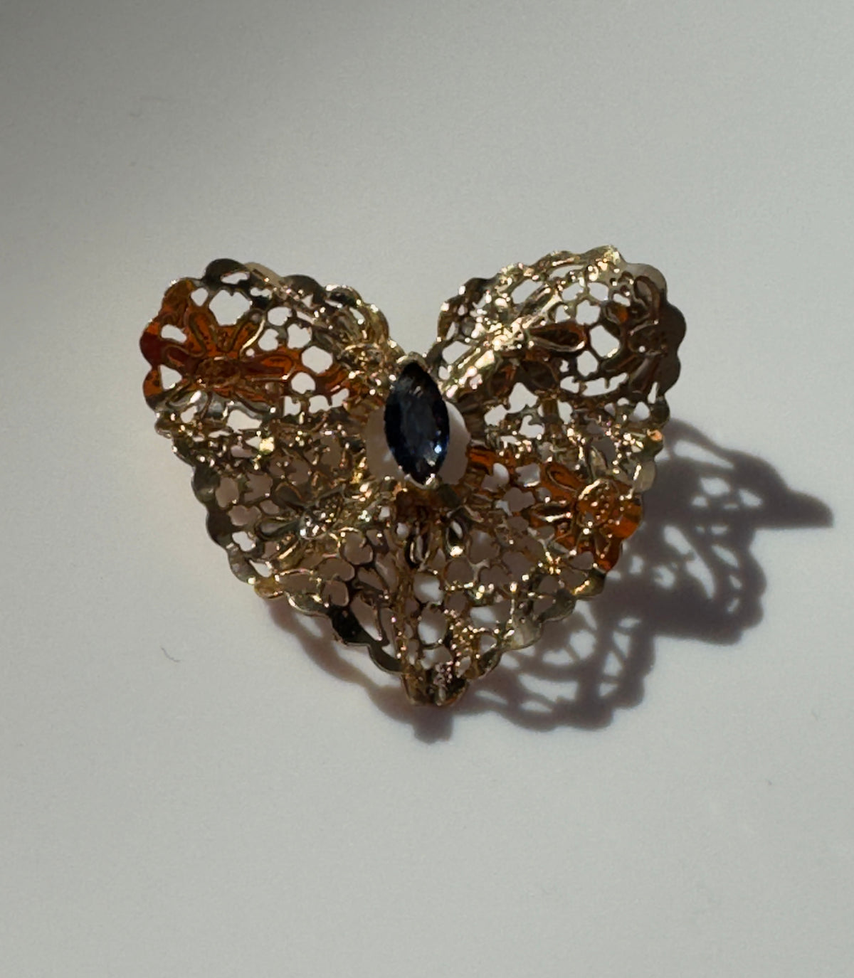 Estate 1980s 14K yellow gold heart slide pendant with blue sapphire centerstone and intricate pierced filigree openwork design