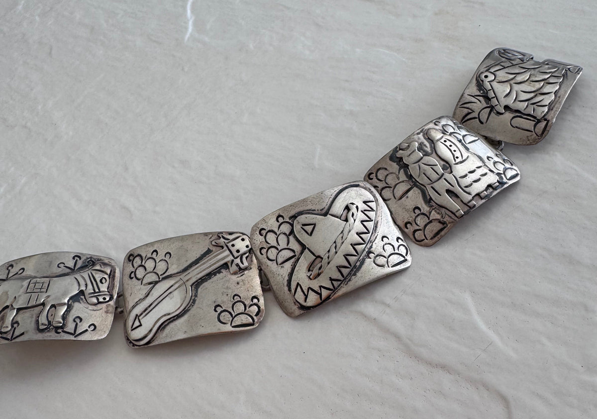 Estate J. Alvarez Taxco Mexican sterling silver storyteller panel bracelet showing detailed cultural scenes with guitar player, pottery, and folk motifs