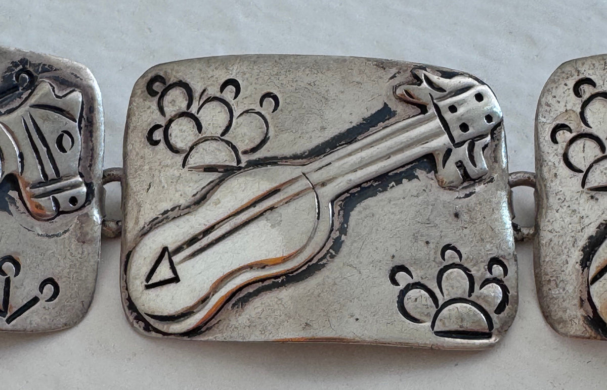 Estate J. Alvarez Taxco Mexican sterling silver storyteller panel bracelet showing detailed cultural scenes with guitar player, pottery, and folk motifs