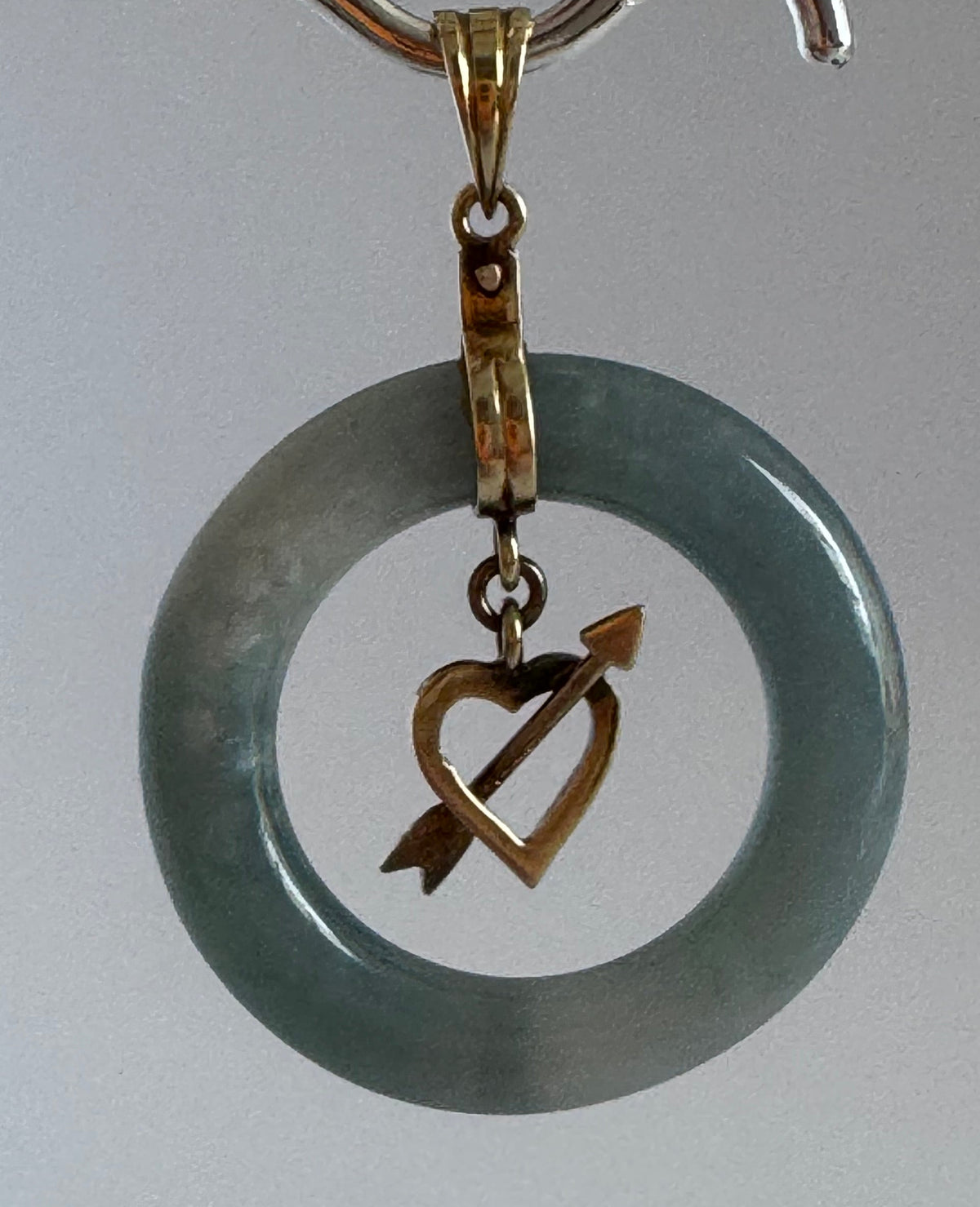 Estate vintage 14K yellow gold blue jadeite circle pendant with heart and arrow motif, showing translucent stone and quality gold framework