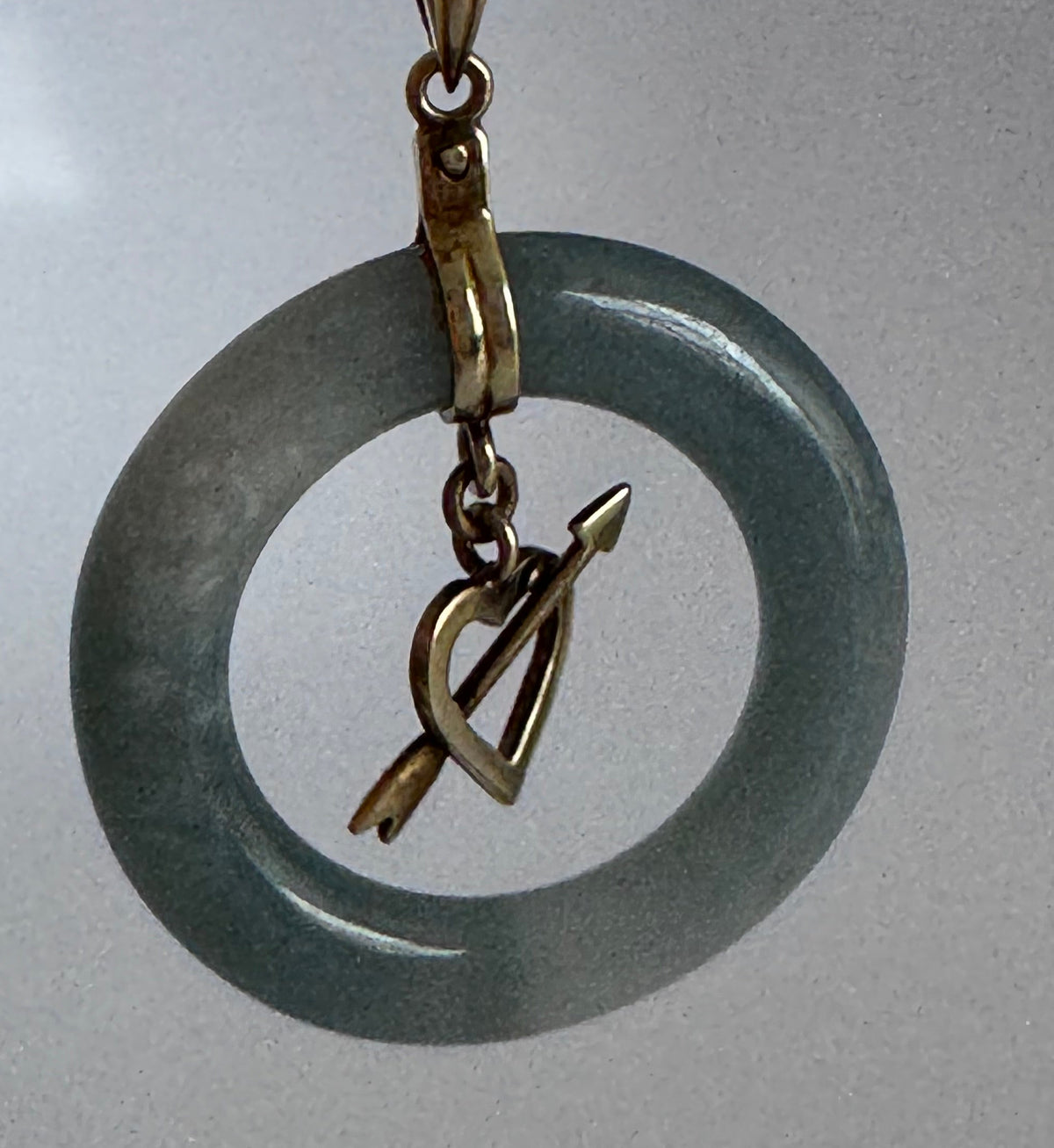 Estate vintage 14K yellow gold blue jadeite circle pendant with heart and arrow motif, showing translucent stone and quality gold framework