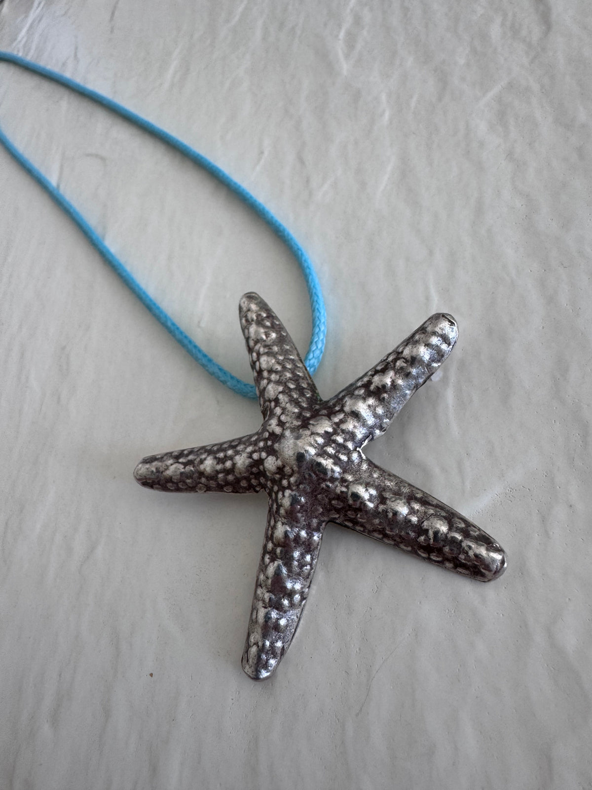 Large Karen Hill Tribe silver starfish pendants with textured surface showing authentic handcrafted details and hidden bail construction