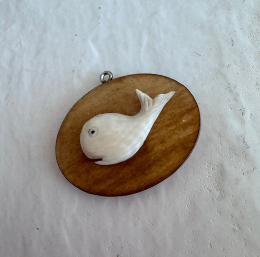 Vintage scrimshaw-style carved whale pendant on natural wood oval with sterling silver bail