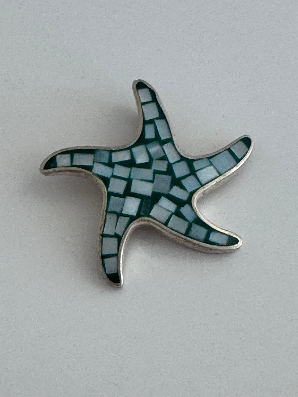 Vintage sterling silver starfish pendant with mother of pearl and green resin mosaic inlay, showing detailed craftsmanship and 925 hallmark