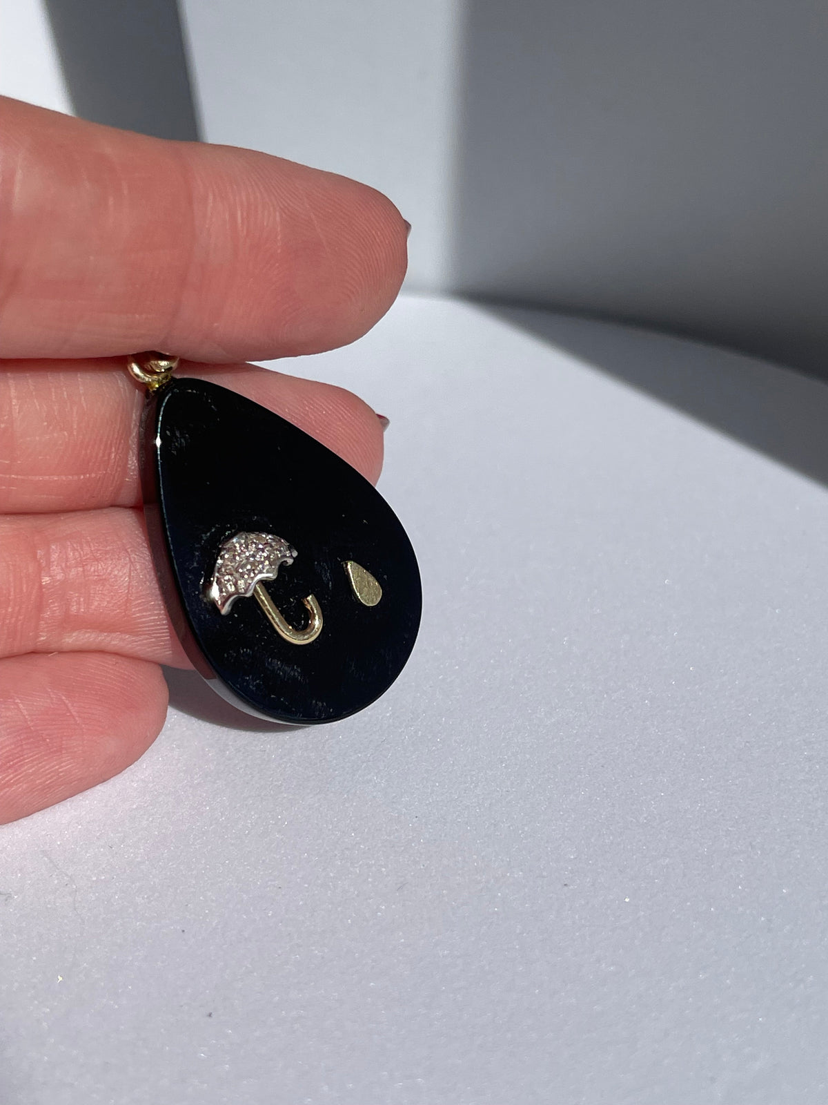 Estate 14K gold black onyx teardrop pendant with inlaid umbrella and raindrop design, diamond accent, 1980s whimsical jewelry