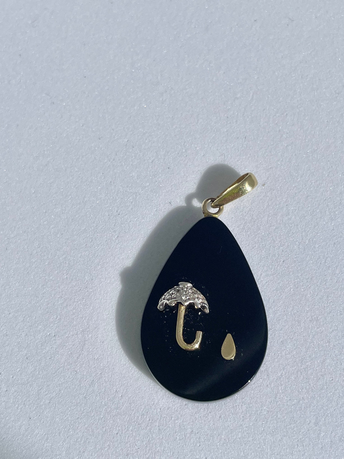 Estate 14K gold black onyx teardrop pendant with inlaid umbrella and raindrop design, diamond accent, 1980s whimsical jewelry