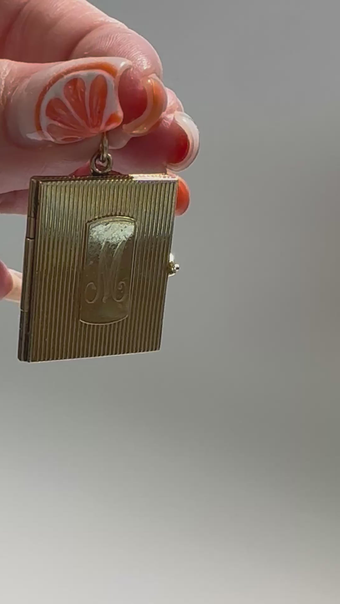 Vintage 14K gold book locket with hinged pages, engine-turned texture, engraved details, multiple photo compartments